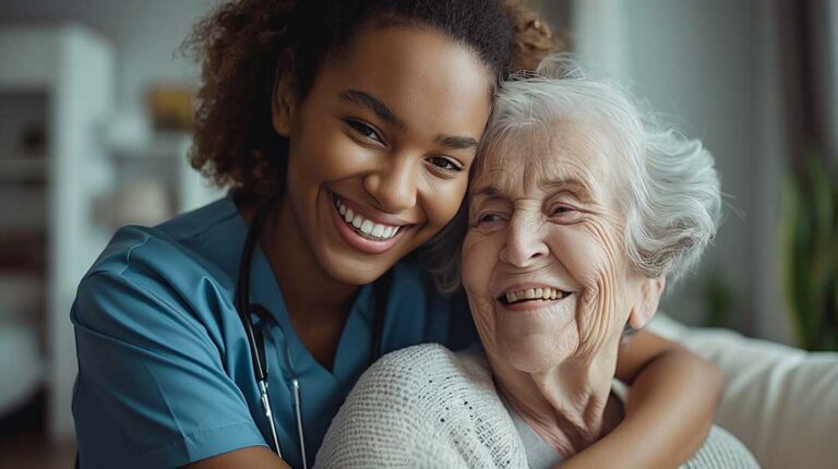 An adult daughter and her senior mother sit together at a kitchen table having a heartfelt conversation.